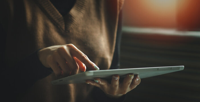Woman's hands holding and using a digital tablet. business technology background. banner desing, IoT, internet of things.	