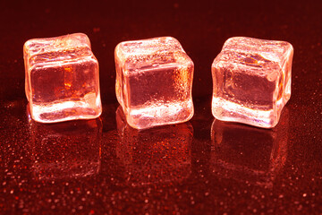 Red ice cubes on black background.