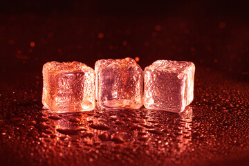 Red ice cubes on black background.