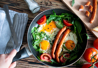 Breakfast. Fried eggs and sausages. On a wooden background