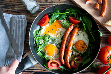 Breakfast. Fried eggs and sausages. On a wooden background