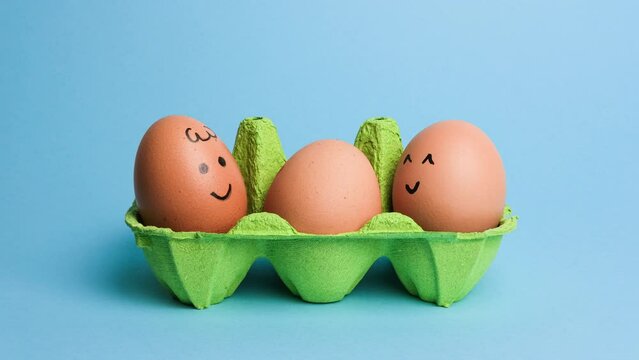 Cute easter eggs with funny faces in green box isolated on blue background. Happy easter concept. Stop motion easter animation