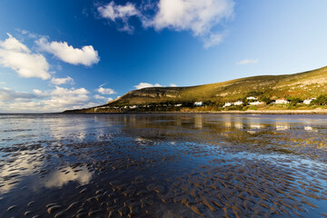 Reflection of the Great Orme from the water pooled beach surface of the estuary on the River Conwy, West Shore, Llandudno, North Wales