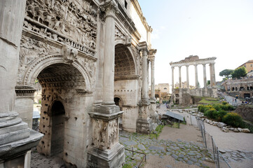 The Temple of Saturn and the white marble Triumphal Arch of Septimius Severus. Ancient monuments...