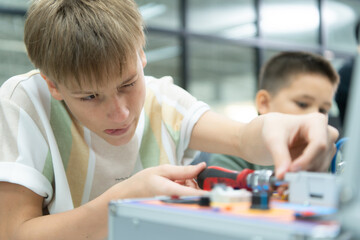 Youngsters utilizing the hand robot technology are having fun learning the electronic circuit board and hand robot controller of robot technology, which is one of the STEM courses.