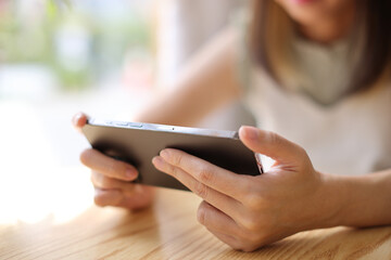 Woman hand using a smartphone for Stock exchange trading online in the coffee shop, business concept