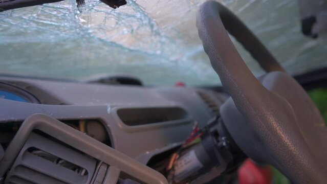 The destroyed dashboard and cracked windshields of a car after an accident.