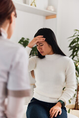 An Asian female patient had a migraine attack during the female doctor's examination.