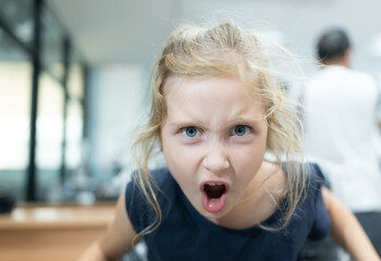 Portrait of little girl with blond hair in the hairdressing salon