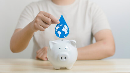 Woman holding a drop of water to be dropped into a piggy bank