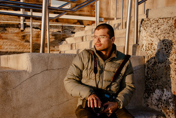 Man sitting on steps, early morning as sun rises