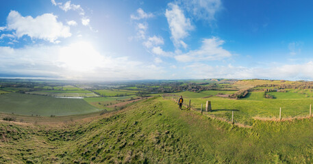 Obraz premium backpacker walking on footpath, beautiful hill and landscape near Pewsey, South of England, United Kingdom