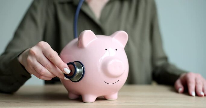 Seo manager woman listens to piggy bank with stethoscope