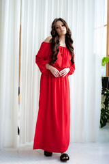 Beautiful smiling woman in long red dress sensual posing