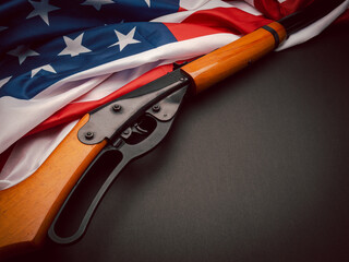 Top view of a shotgun over the American flag on a black background