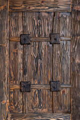 Old ancient antique door made of roughly hewn dark wood. Abstract wooden background.