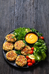 crab cakes with sauce, lettuce, tomatoes, lemon