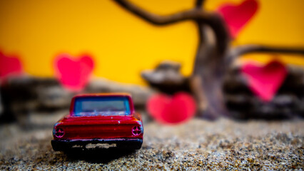 Minahasa, Indonesia : December 2022, toy car with gradient orange background and a heart