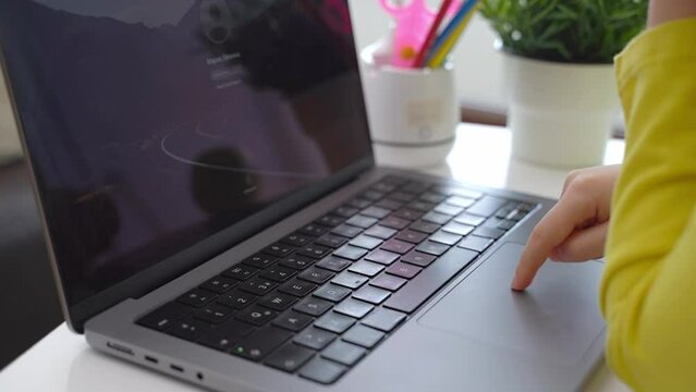 Cute smart caucasian primary School Child typing on the keyboard laptop. Online tutor teaching digital class, web lesson programming on computer at home. Virtual education. Schoolboy girl studying