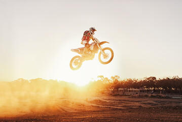 Fototapeta na wymiar Taking it one jump at a time. A shot of a motocross rider in midair during a race.