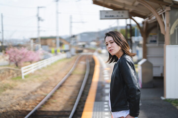 ローカル線の無人駅にいる女性