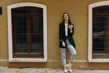 Woman blogger smile with teeth with a phone in her hands walks around the city fashion on the street, spring travel, vacation in the city tourist freelancer, mobile communication and internet for work