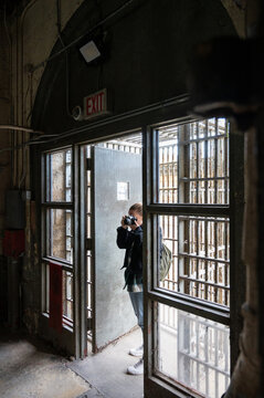 Smiling young girl visiting and taking pictures in the cell galleries of the Old Joliet Prison
