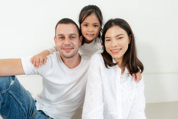 Obraz premium Happy family portrait with parents and little daughter.