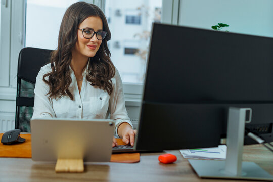 Young business woman working at her desk at her down town office, she's a paralegal working on a new case
