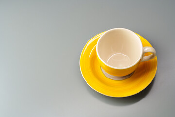 Top view of ceramic cup with saucer on gray background