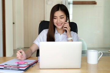 Asian busy employee, Young asia business woman holding paper while working and talking phone at home office table, Happy office girl working, business people casual lifestyle