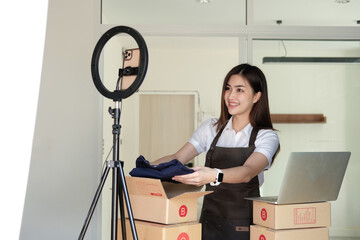 Female business owner packing online order to delivery, Freelance woman seller prepare parcel box of product for deliver to customer. Online selling, e-commerce, shipping concept.