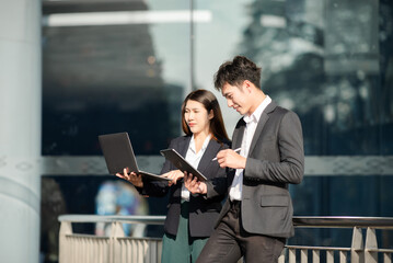 Kind leader executive manager share and discuss business solutions plan ideas on tablet with Asian female marketing manager in modern office..