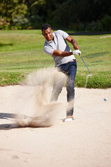 Its all about handicaps and hazzards. a handsome young man playing a game of golf.