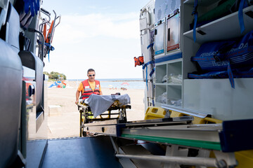 Lifeguard worker working on an ambulance on the beach