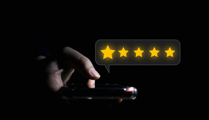 businessman giving five stars rating via smartphone