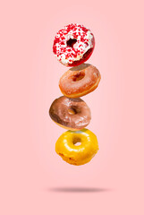 Levitating donuts isolated on a pink background. Modern food concept. Advertising for pastry shops,...