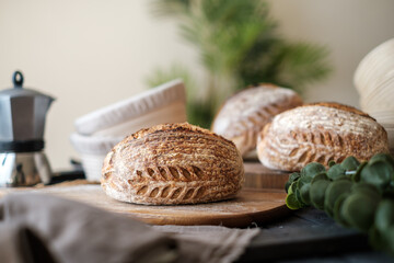 Artisan Batard Sourdough healthy Bread with leaf scoring. Open crumb high hydration Sourdough bread set on white table. - 581414117