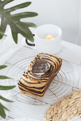 Chocolate marble loaf cake with chocolate glaze. On white cafe table. - 581414153