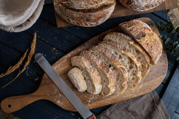Artisan Batard Sourdough healthy Bread with leaf scoring. Open crumb high hydration Sourdough bread set on white table. - 581414156