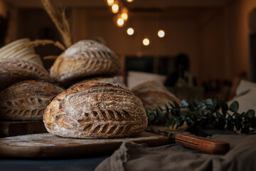 Artisan Batard Sourdough healthy Bread with leaf scoring. Open crumb high hydration Sourdough bread set on white table. - 581414157
