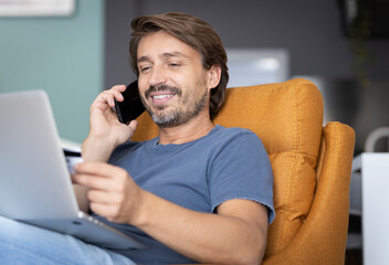 Man talking on the phone while making a payment from home