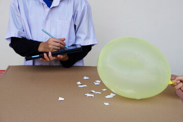 Closeup student doing science experiment about static electricity lesson from balloon. Observe ,takes note. Concept, Action research. Science project work. Learning by doing and observing. Education. 