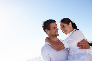 Obraz premium Keeping her close. a young man carrying his girlfriend along a beach.