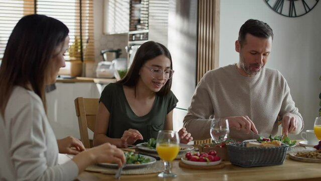 Caucasian family of three sharing breakfast food together. Shot with RED helium camera in 8K. 