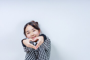 	両手でハートを作るカメラ目線の女の子