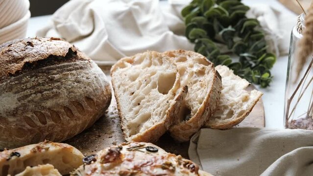Artisan Batard Sourdough healthy Bread with leaf scoring. Open crumb high hydration Sourdough bread set on white table.