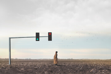 surreal woman observes the arrows of a traffic light in the middle of the desert, concept of...
