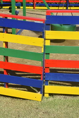 Primary Color Blue, Yellow, Green, and Red Wooden Fence  around a Playground