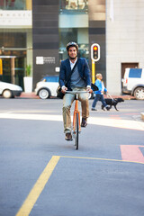 Getting some exercise on the way to work. a handsome businessman traveling to work by bicycle in the city.